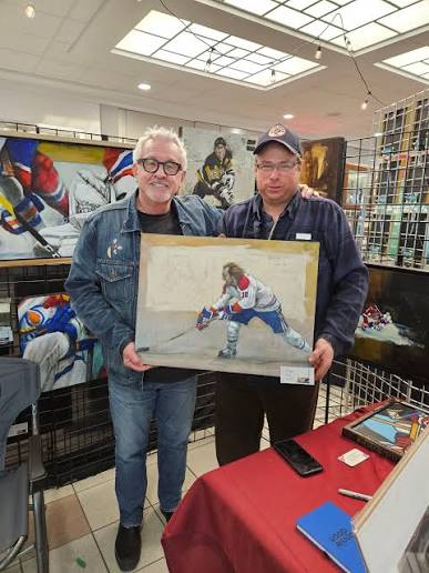 Stuart Adams at an art gallery event with a hockey-themed painting